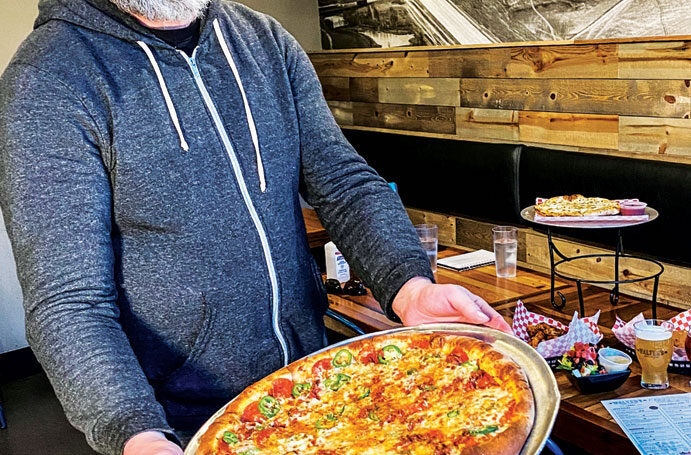 Trent Brotherton holding a perfect pizza pie